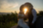 Mountain elopement location backdrop during golden light sunset with couple kissing cowboy hats