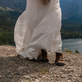 bride's hiking boots and wedding dress flying in the wind glacier national park