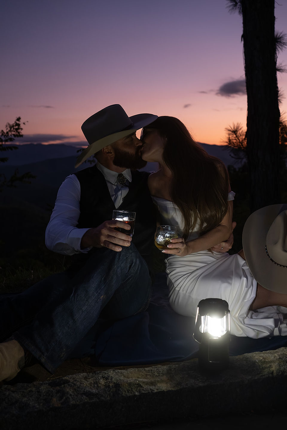 bride and groom kiss at dusk with tennessee mountain backdrop and lit by lantern lihjy