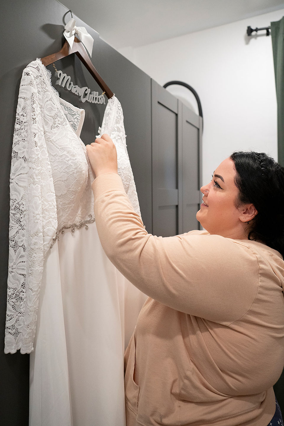 elopement bride looks at wedding dress on personailzed hanger