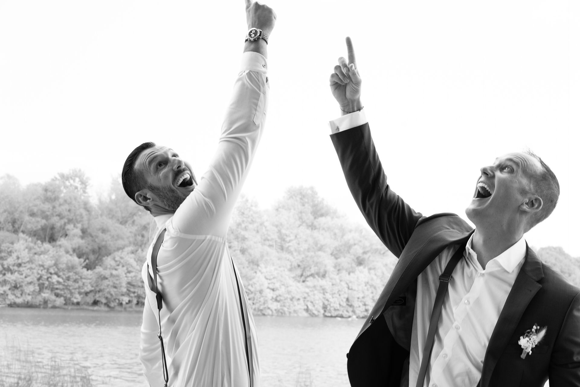 groom and first man being silly light house on the lake