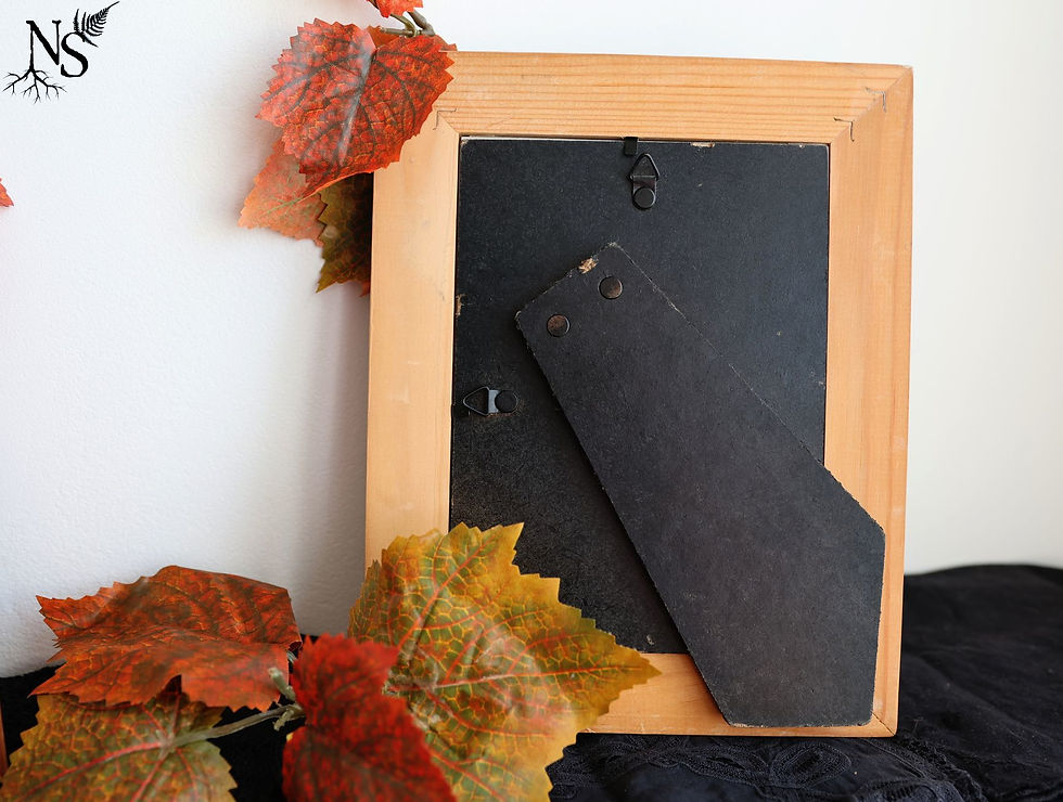 Thumbnail: The back of a wooden frame with a hanging hook and a standing prop