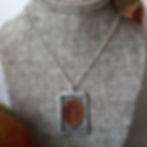 a necklace with a real pressed fall leaf in a stained glass pendant