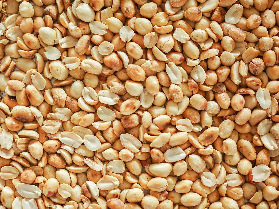 Close-up of roasted peanuts with shells removed, displaying a variety of golden and light brown hues.