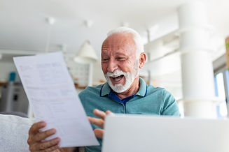 Surprised laughing happy old mature retired man looking through paper document, feeling ex