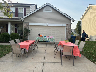 Two tables set up with donuts on the driveway.