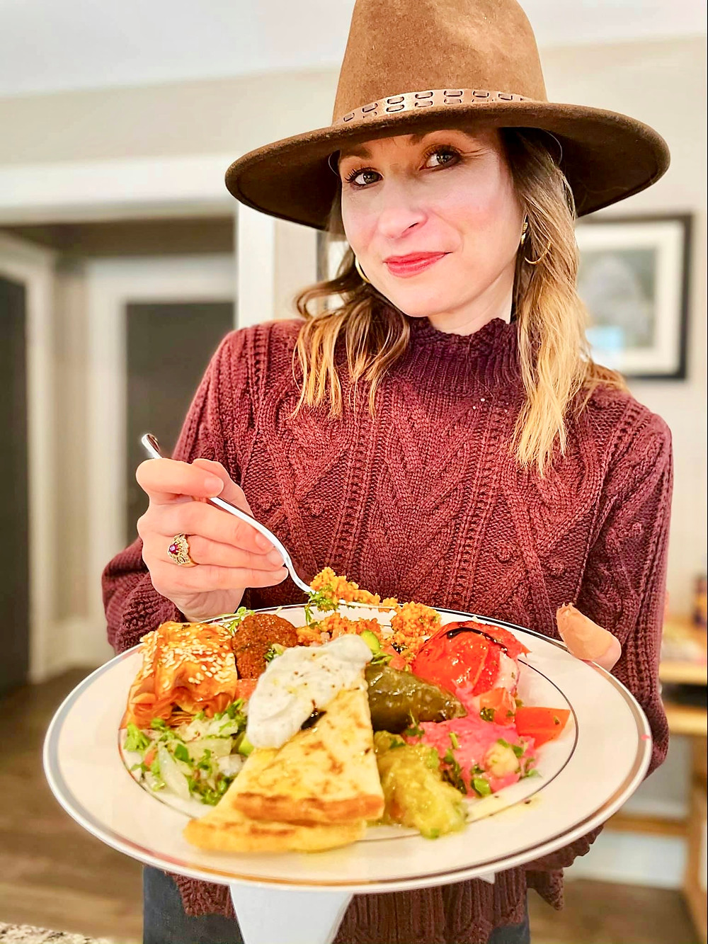 woman in hat eating plate of food