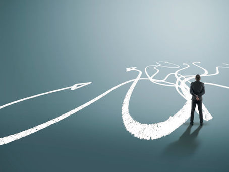 A man stands at the beginning of several converging paths. Some are short, some are long. They all appear to made with chalk.