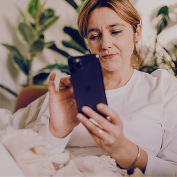 A middle-aged woman texting on her phone