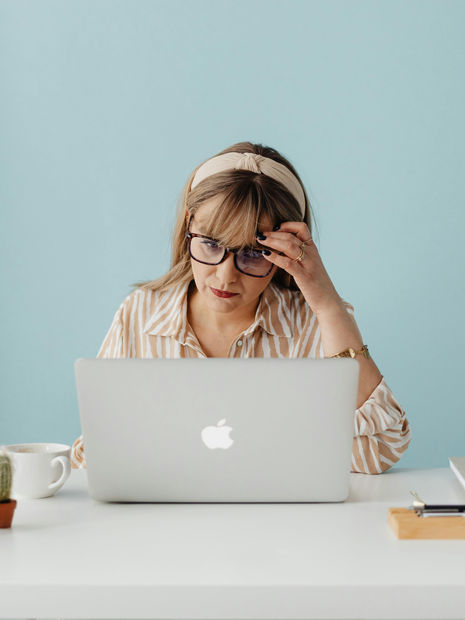 Woman rubbing her temples at laptop | Cornerstone Well