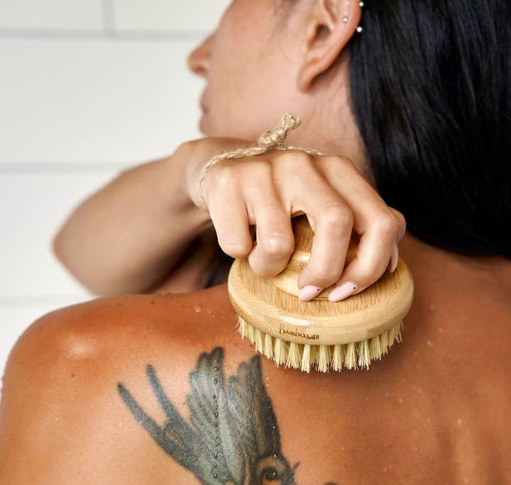 A woman using Bamboo Body Dry Brush