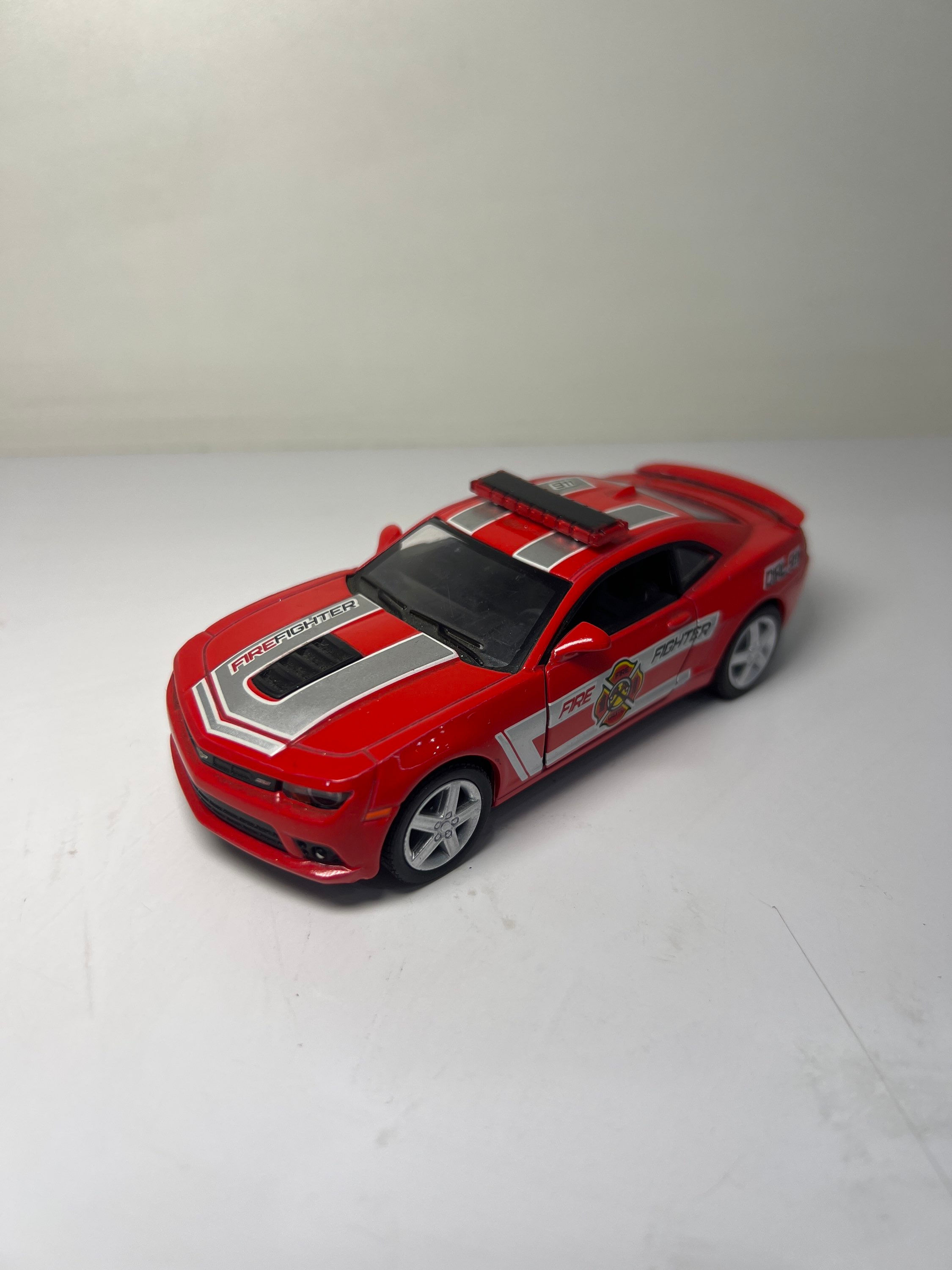 Carro de bombeiros vermelho com texto e detalhes em cinza, em fundo branco.