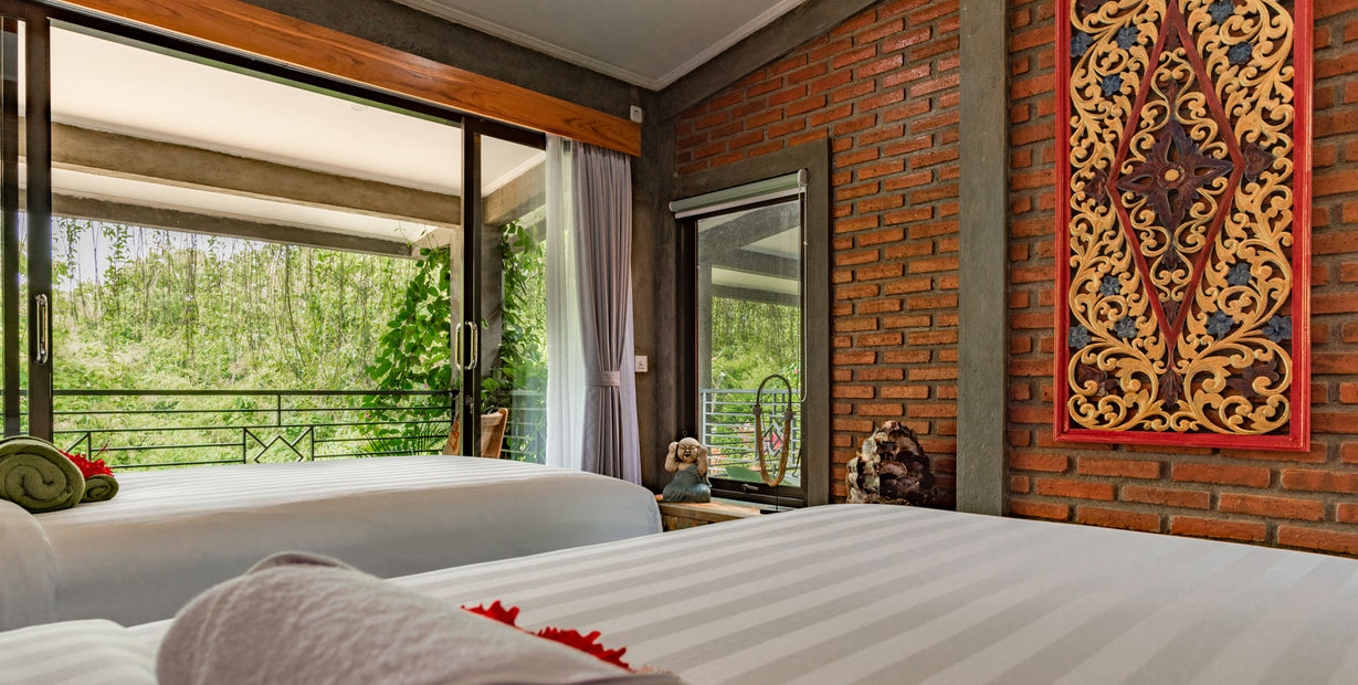 Spacious bedroom with two beds, balcony view