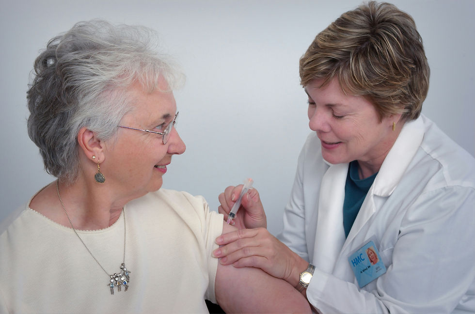A nurse in a white coat administers a vaccine to a smiling elderly woman in a light shirt. Blue background, calm and positive mood.