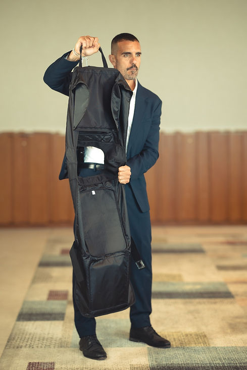 Man in suit holding a Shibumi Gear golf bag.