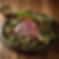 Fresh power greens based salad with cherry tomatoes and perfectly cooked porked loing on top