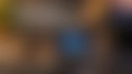 echtes 15-Tasten-Stream-Deck auf warmem Schreibtisch mit Titel zu KI-Assistenten.