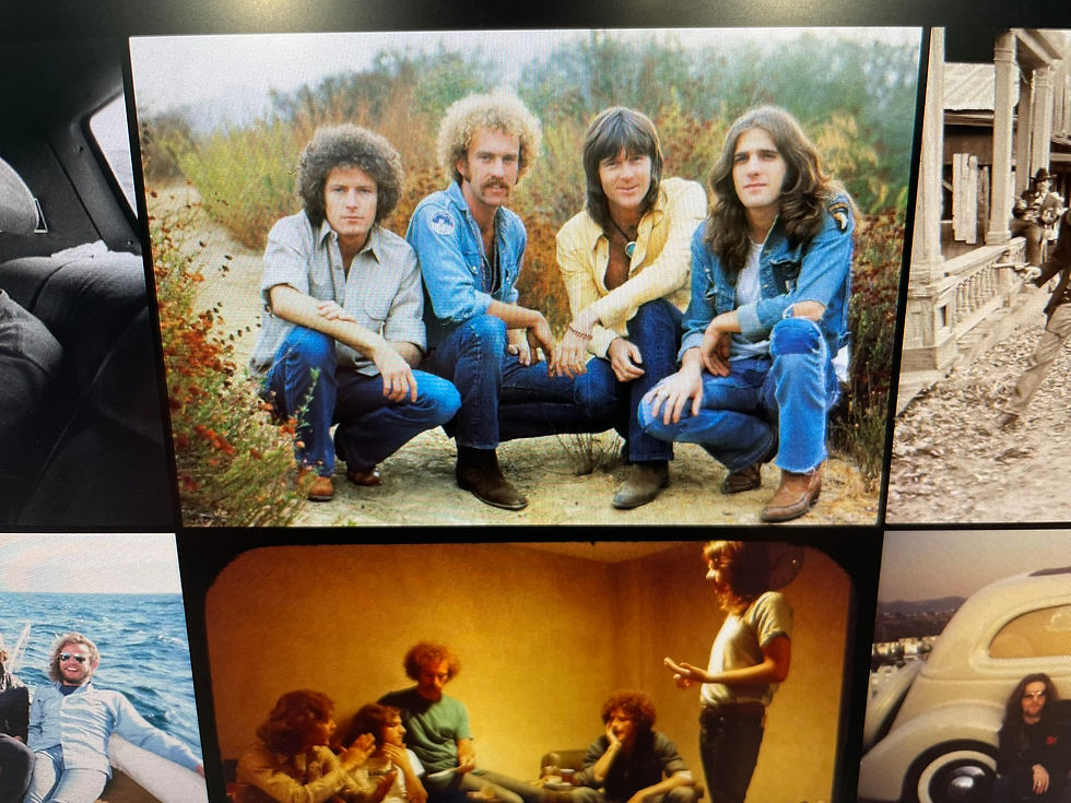 Eagles band members Don Henley, Bernie Leadon, Randy Meisner, and Glenn Frey crouching outdoors in 1970s denim and casual attire.