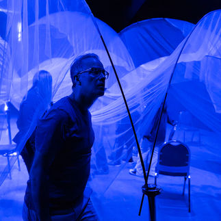man facing right in a dark blue room
