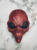 bath bomb in the shape of a red alien head with black eyes