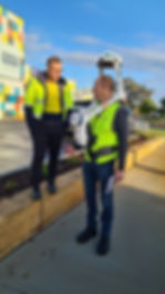 Two men stand talking at the front od Eaton Fair. One of the men is wearing the NavVis VLX. 