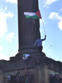 A teenage boy waves the Palestinian flag on the public square in Glasgow.