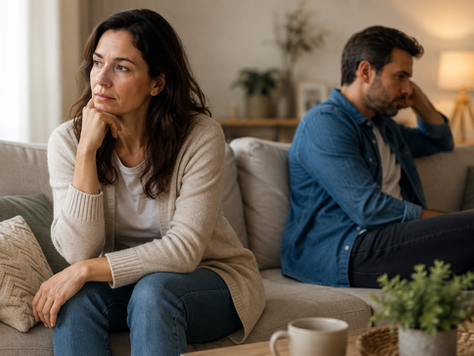 Un couple assis à distance sur un canapé, l'un des partenaires cherchant le contact tandis que l'autre reste en retrait, illustrant le sentiment de faire toujours le premier pas dans son couple.