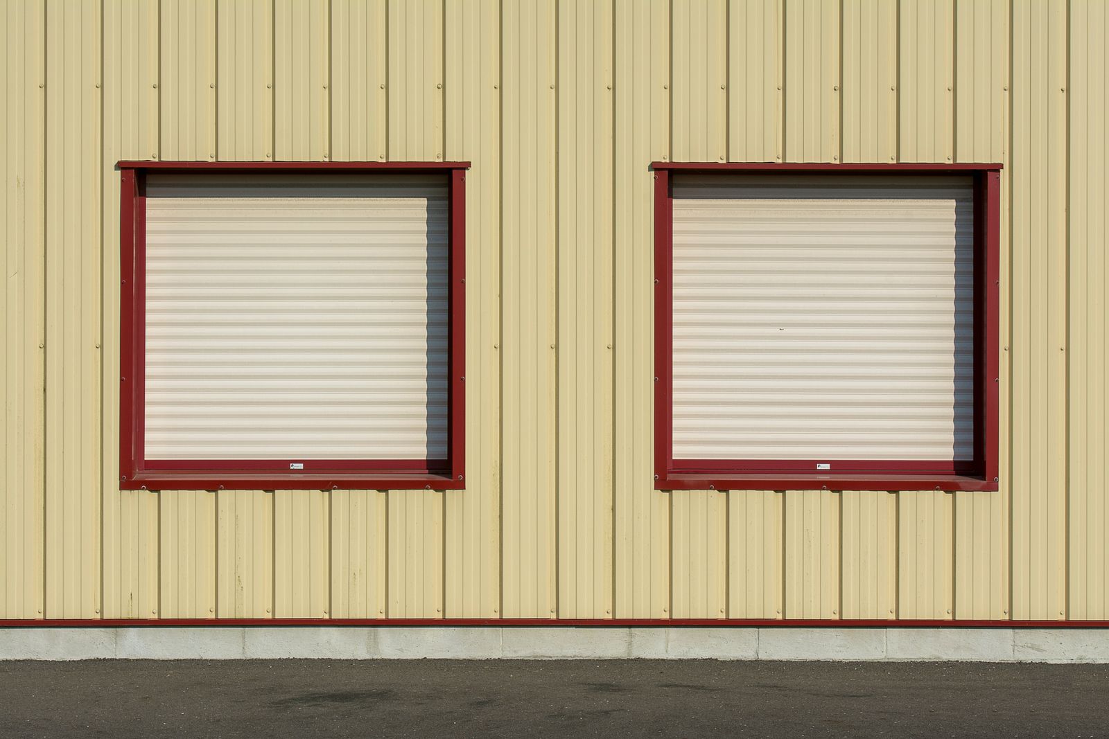 Two closed roller shutters on the facade of an industrial building