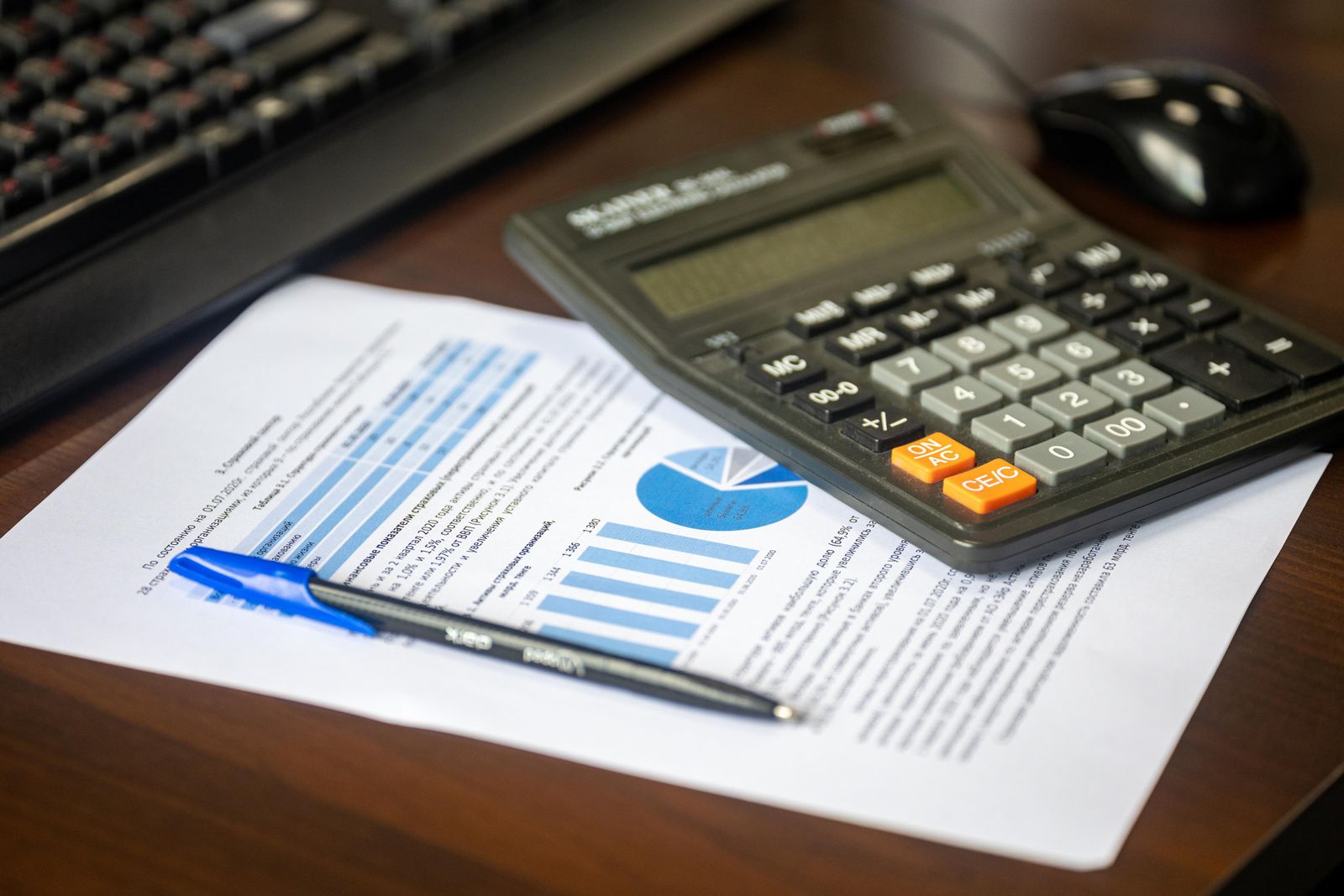 Calculator and pen resting on a printed financial report