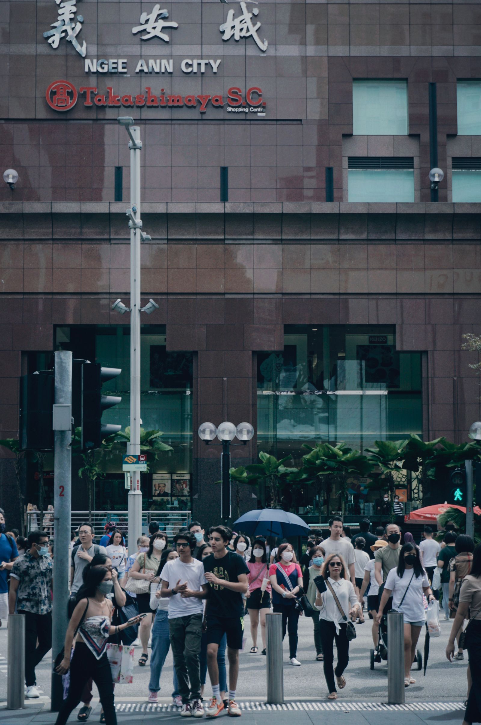 Pedestrians crossing Orchard Road at a junction outside Ngee Ann City
