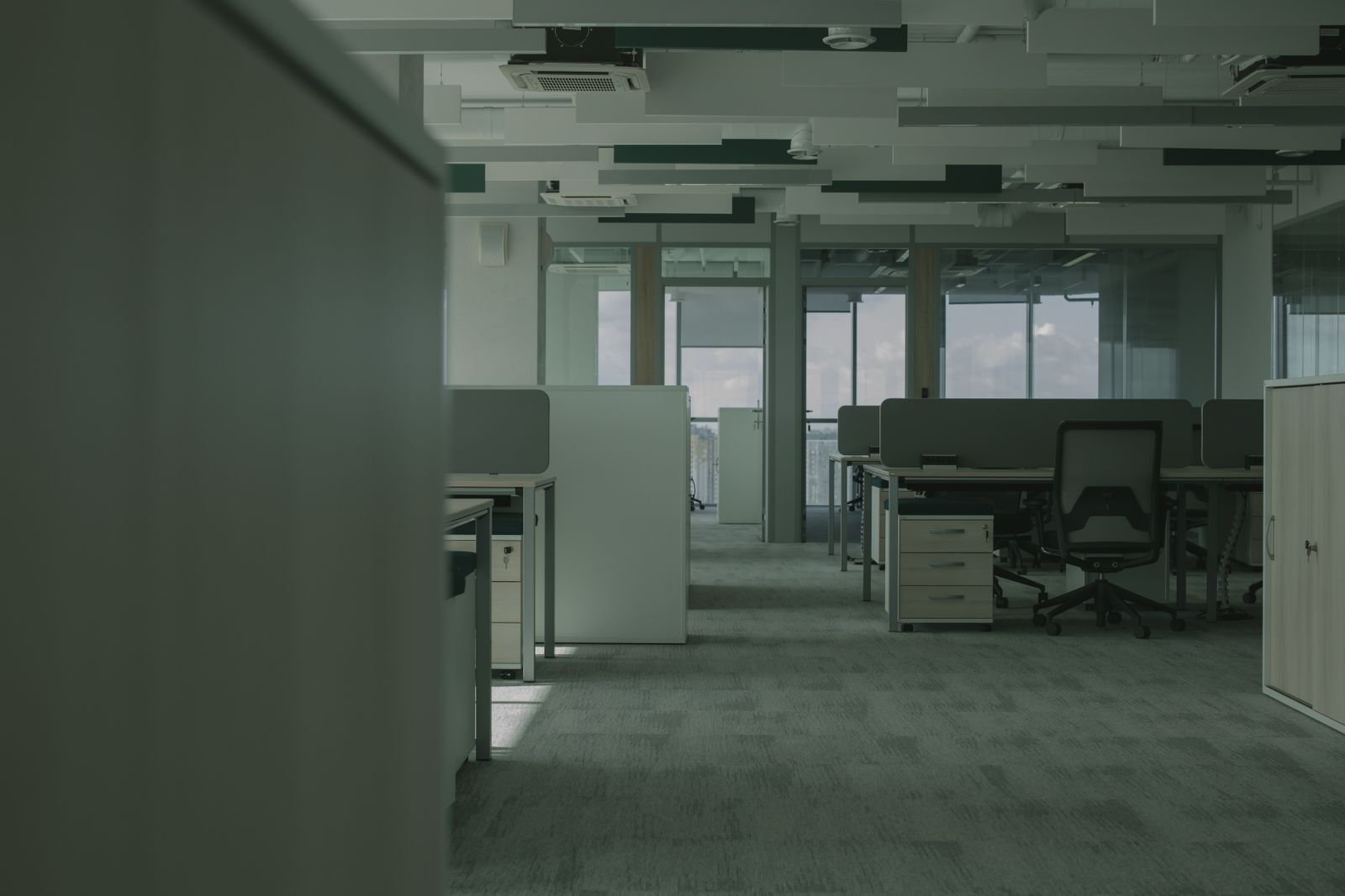 Empty open-plan office floor with desks, chairs and partitions