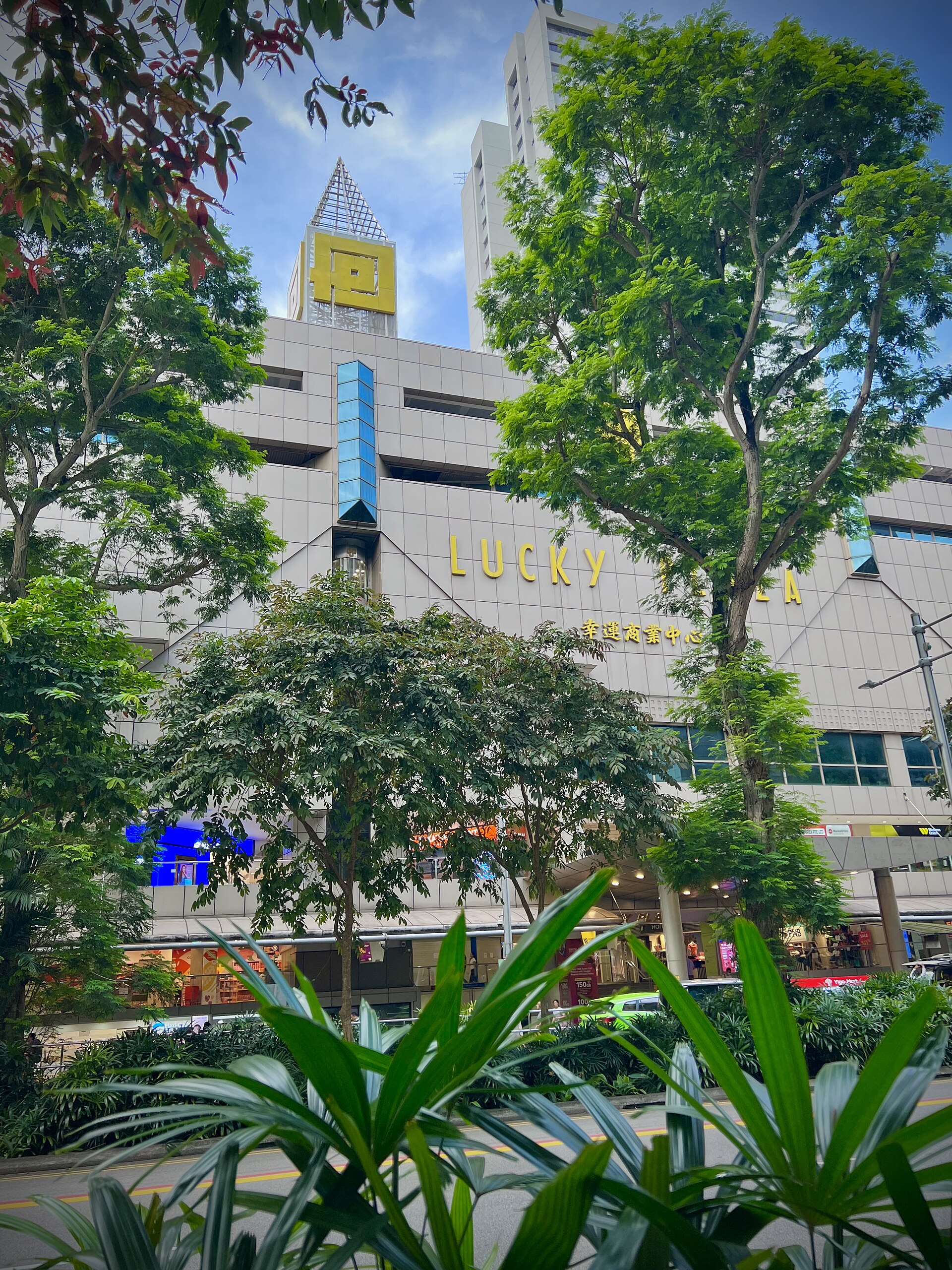 Lucky Plaza on Orchard Road seen through roadside trees
