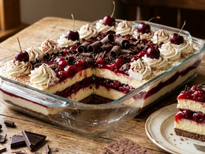 Layered Chocolate Cherry Cheesecake Icebox Cake in a glass dish, topped with whipped cream and cherries, beside a plated slice on a rustic table.