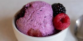 Berry cottage cheese ice cream scooped into a bowl with fresh berries on the side