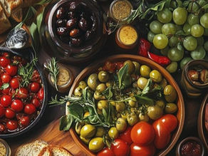 A vibrant spread of fresh bread, cherry tomatoes, olives, grapes, and dipping sauces on a wooden table, evoking a Mediterranean feast.