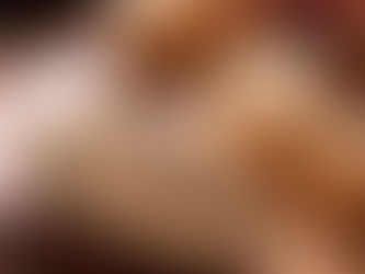 Freshly baked bread rolls on a wooden board, with a basket and colorful cloth in the background, creating a warm, rustic feel.