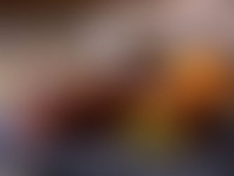 Chocolate bars with pistachio filling on a slate with scattered nuts, shredded carrot, and a steaming cup in the background. Cozy mood.