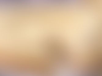 Creamy lemon cheesecake on a plate with a slice removed. Topped with piped cream and lemon zest. Pleasant and inviting ambiance.