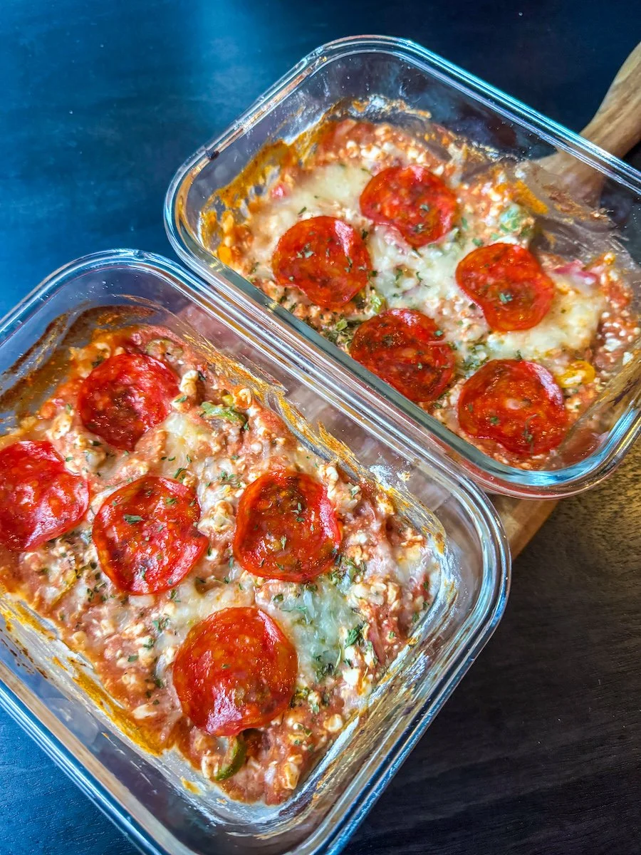 Baked cottage cheese pizza bowl topped with melted mozzarella, pepperoni slices, marinara sauce, and Italian herbs in a glass baking dish.