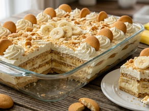 Banana pudding icebox cake in a glass dish, topped with whipped cream and cookies, with banana slices and a plated square on a rustic table