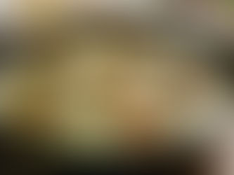 Creamy chicken with spinach in a skillet on a wooden table, garnished with herbs. A glass of white wine and a bowl of cheese nearby.