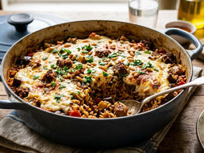 Baked rice with cheese, meat, and herbs in a blue pot on a wooden table. A spoon serves a portion onto a plate. Fresh parsley nearby.