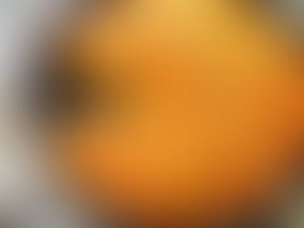 Cornbread skillet with a slice removed on a plate, topped with butter and syrup. Rustic setting with a green cloth and textured surface.