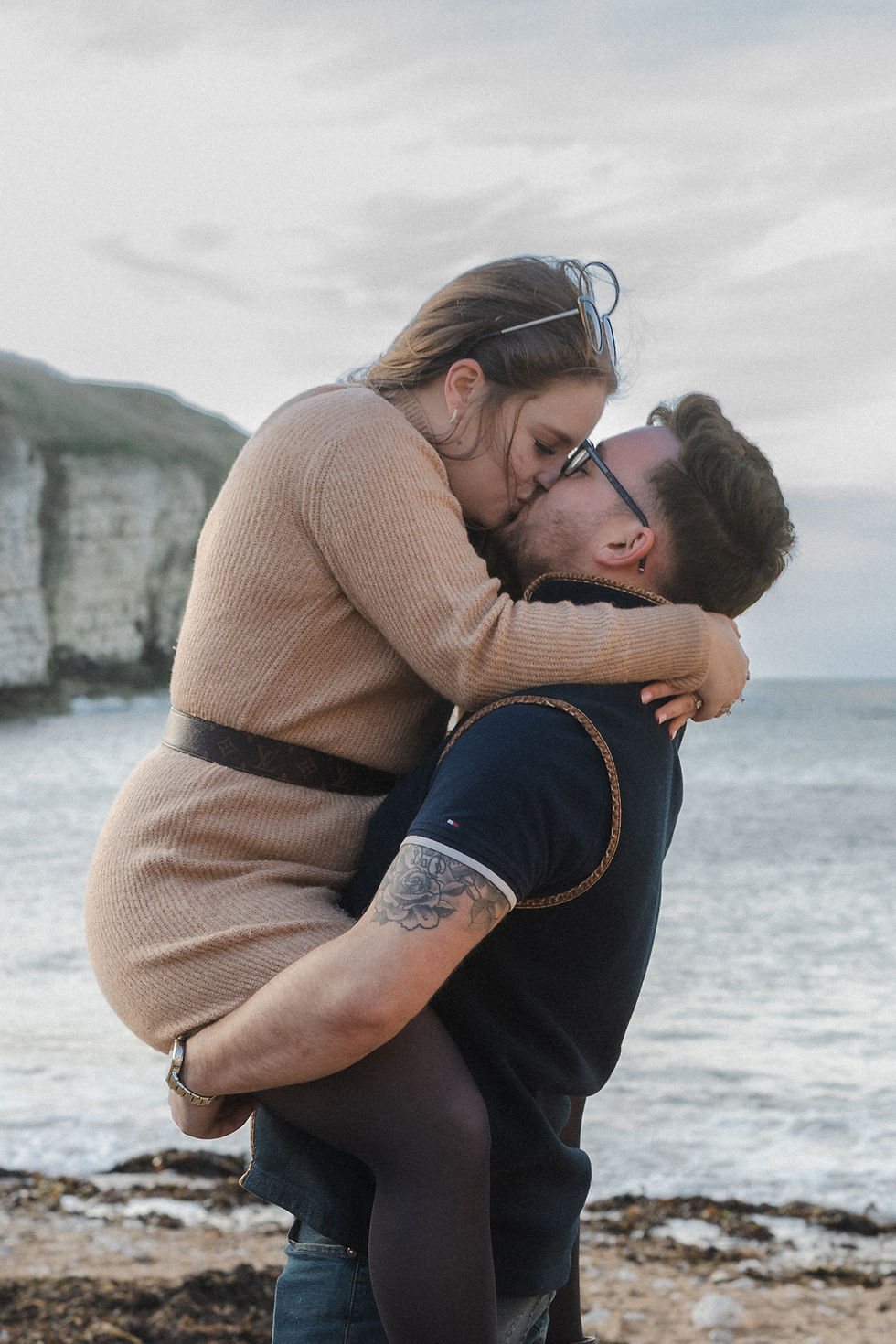 Couple kissing on Flamborough Head beach during their engagement shoot
