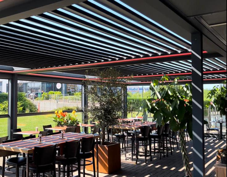Vue à hauteur d’œil d’une terrasse de café avec plantes et éclairage d’ambiance