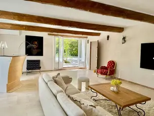 Luxury living room with exposed beams and refined décor in a traditional Provençal villa designed for a family-friendly vacation rental.