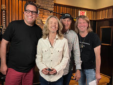 Behind the scenes of Frampton: group photo in a wood-panelled studio