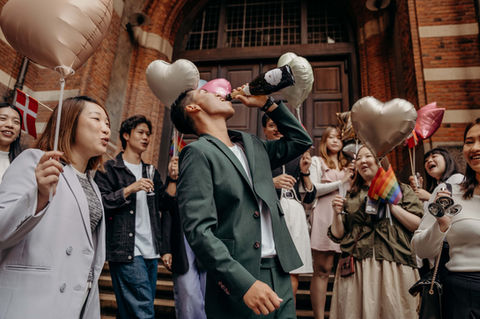 Groom drinking and celebrating surrounded with friends