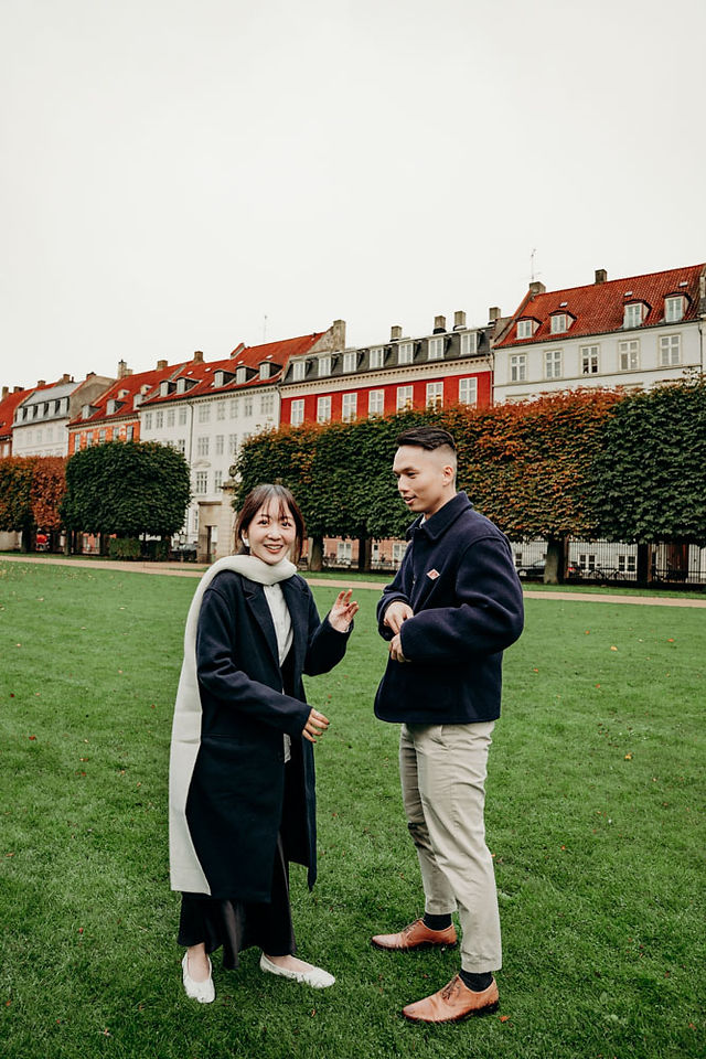 Couple celebrating their engagement in a natural setting surrounded by fall colours in Copenhagen.