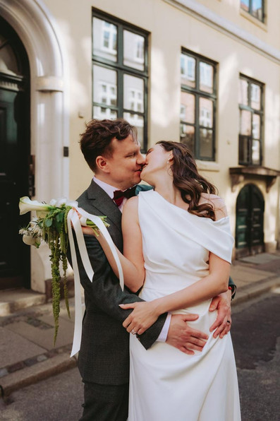 Newlyweds walking through historic Magstræde street in Copenhagen after wedding ceremony